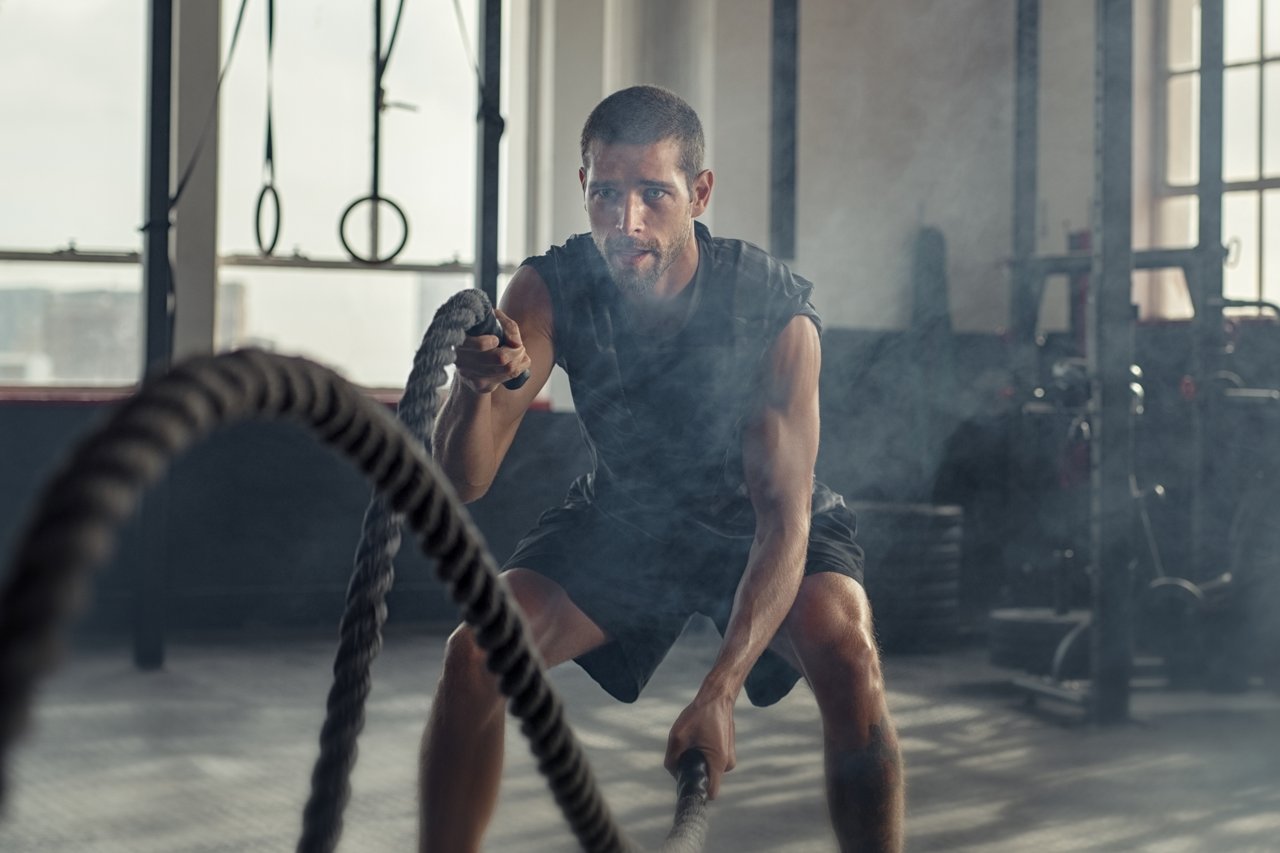 Un hombre haciendo un entrenamiento con cuerdas en el gimnasio