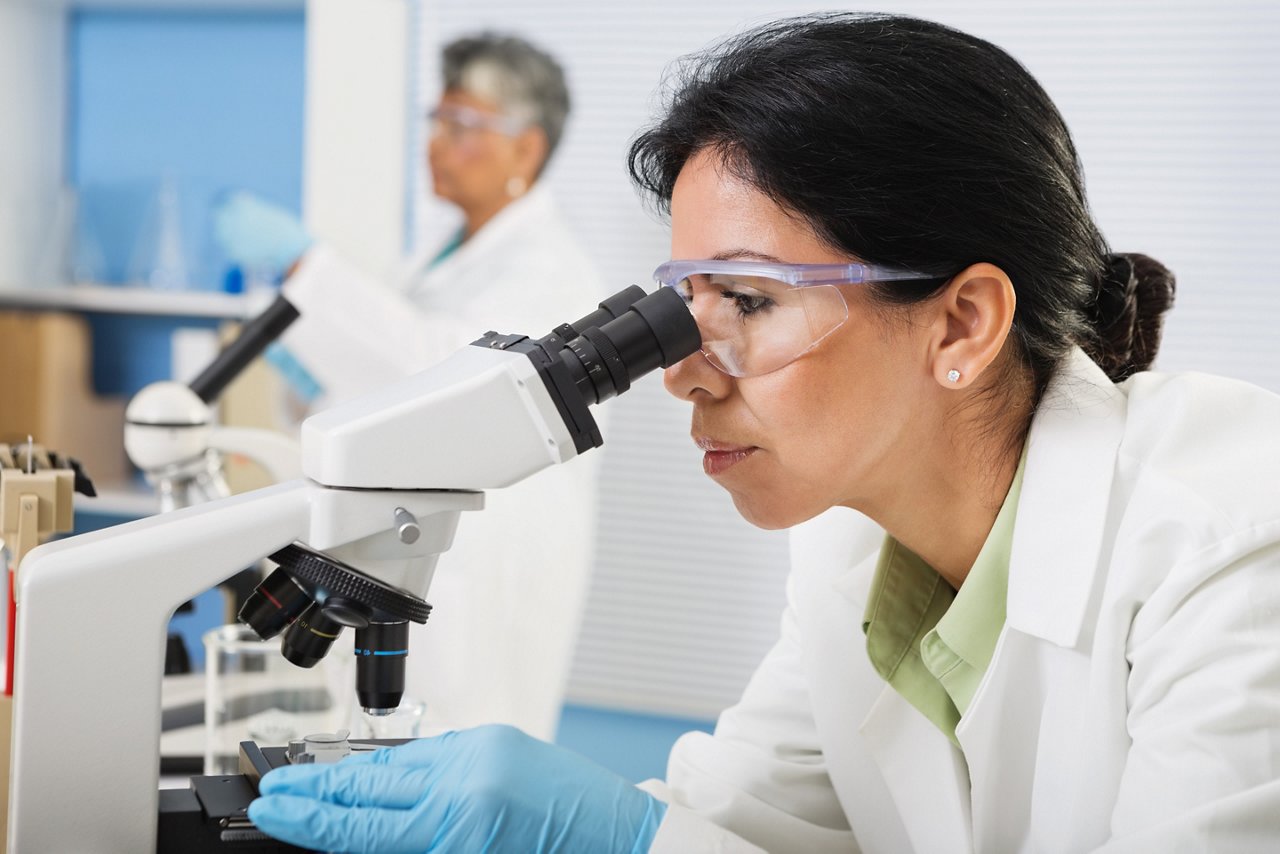 A scientist looking through a microscope