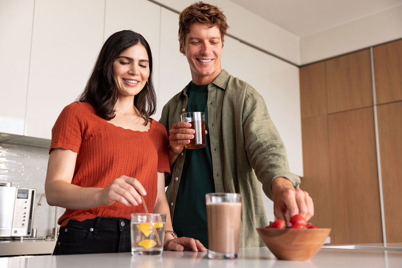 Couple pouring a protein shake in their kitchen