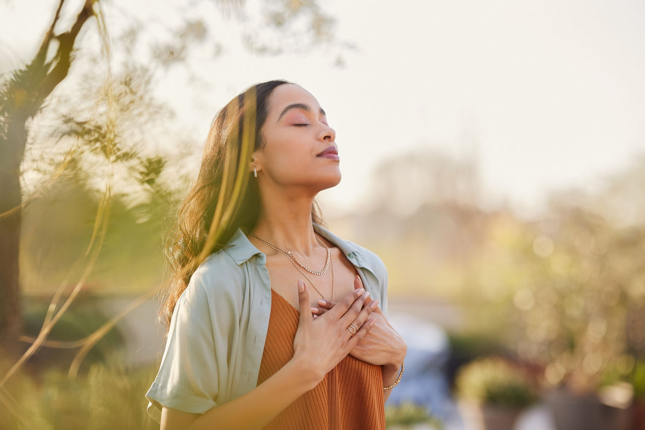 Femme se relaxant et respirant l'air frais en plein air au coucher du soleil