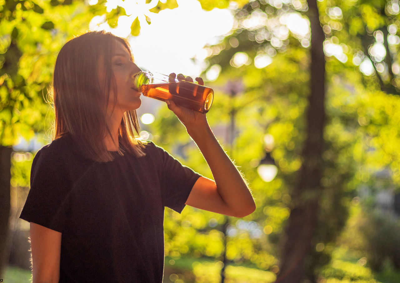 Donna che beve una bevanda nel parco