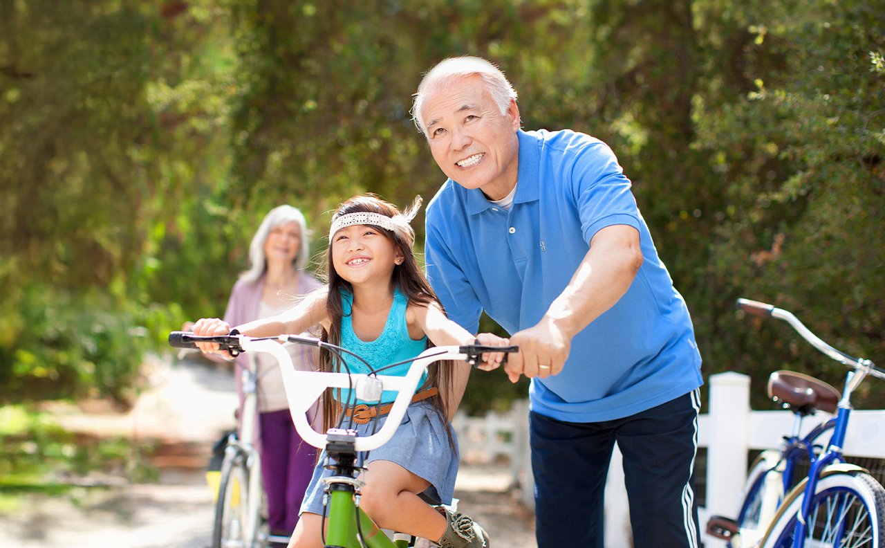 Grandfather of little girl with bicycle